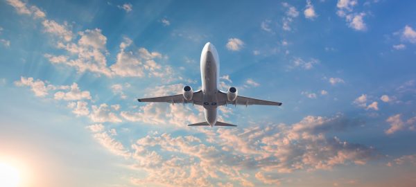 Airplane,Flying,Above,Tropical,Sea,At,Sunset